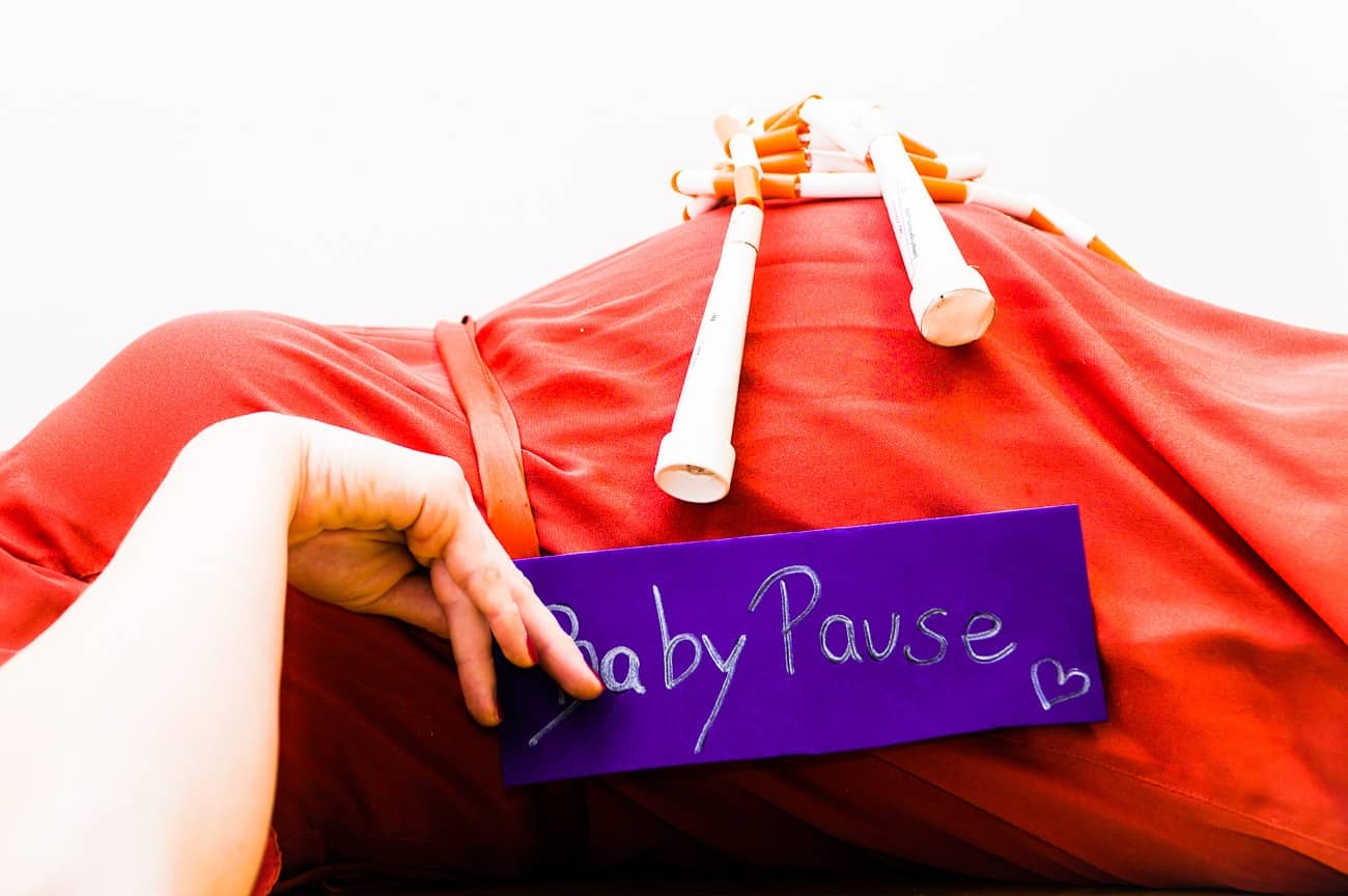 Babypause Schild vor Babybauch